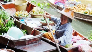 old lady rows her boat with goods in pattaya floating marketing