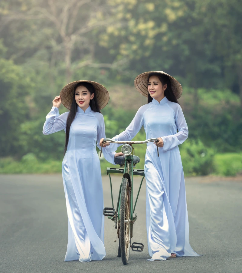 pretty vietnamese girls wearing traditional clothes walk with bicycle